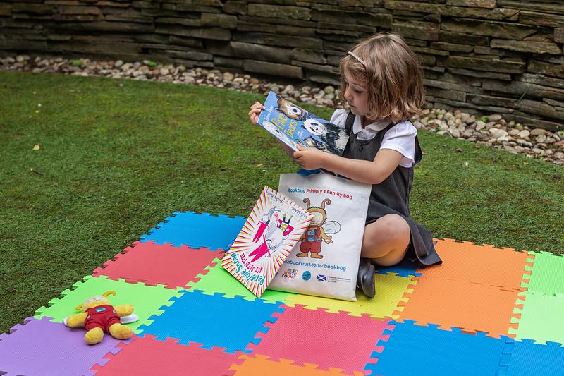 Child looking at the contents of the Bookbug P1 Family Bag 2023